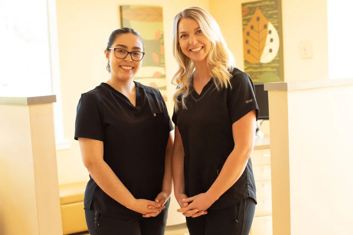 Two Edmonds Orthodontics team members in black scrubs
